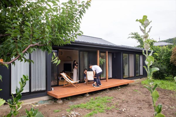 ブラックのガルバリウム鋼板の外壁・鉄板葺きの屋根でモダンな外観に。リビング前に広いデッキを設けました。